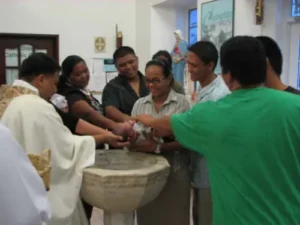 Royce Surigao is baptized. He is held by his parents, Joelyn Sanchez and Roy Surigao, and his four godparents. Godparents are chosen from family or close friends. 0038-F19 01-baptism5