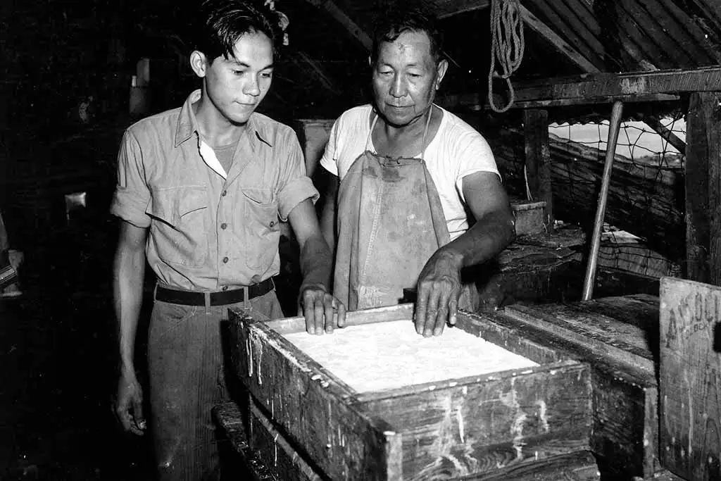 Soap factory process. Josef Martinez Ada (grandfather of former Guam Governor Joseph Ada) and his son, Juan Ada (father of former Guam Senator Tom Ada), at work in the Ada Soap Factory. Photo from the Micronesian Area Research Center (MARC) courtesy of Dr. Anne Perez Hattori.