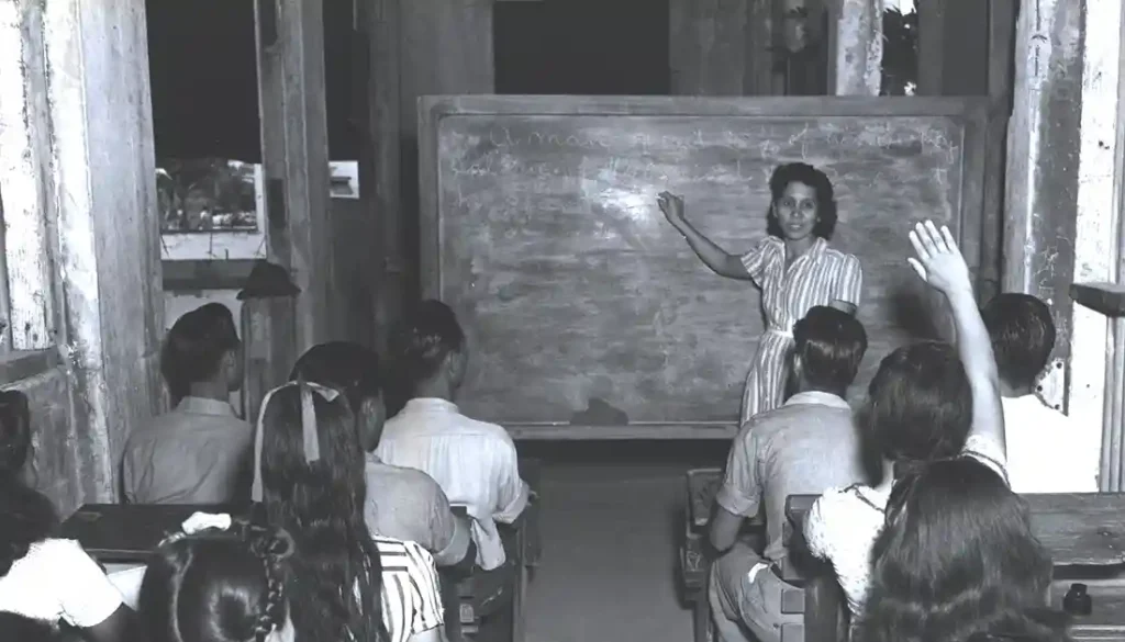 Ana F. Duenas teaching children in bomb-shattered building on January 1945. Micronesian Area Research Center (MARC) collection.