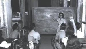Ana F. Duenas teaching children in bomb-shattered building on January 1945. Micronesian Area Research Center (MARC) collection.