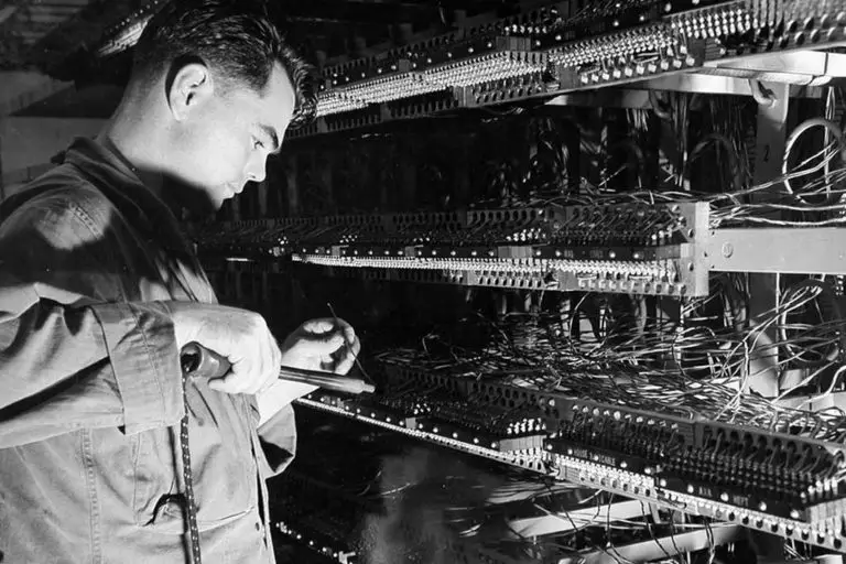 Pfc. Walter Pillows, USA, running in a new jumper at the telephone exchange, Guam, 10 June 1945. National Archives