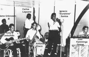 Carlos C. Laguana surrounded by musicians.