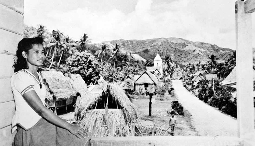 Young Chamorro lady and pre-war Humåtak village scene. Guam Museum collection.