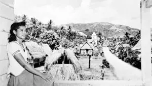 Young Chamorro lady and pre-war Humåtak village scene. Guam Museum collection.