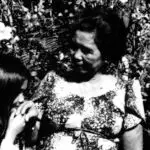 A child nginge's her elder while uttering 'ñora and receives a blessing, "dioste ayudi" in response. Rene Mahone/Micronesian Area Research Center (MARC)