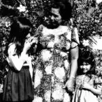 Dioste ayudi-A child nginge's her elder while uttering 'ñora and receives a blessing dioste ayudi in response