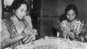 Maria Limtiaco (right) along with her sister, Rita Perez Torres, makes snail shell purses shortly after World War II in Sinajana to sell to visitors to Guam. Photo courtesy of Pale Eric Forbes, OFM, Cap.