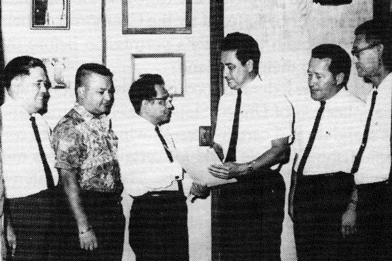 Congressman Antonio B. Won Pat, the newly elected delegate to Washington, receives a congratulatory resolution from the author and his colleges, (from left) Congressmen Florencio "Larry" Ramirez, G. Ricardo Salas, Won Pat, Carlos P. Taitano, Carlos P. Bordallo and Thomas R. Santos. Photo courtesy of the Department of CHamoru Affairs from the Nieves Flores Memorial Library.