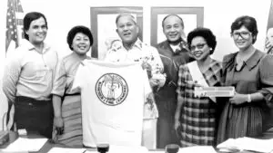 Governor Ricardo Bordallo proudly receives a t-shirt from the Chamorro (CHamoru) Language Commission.