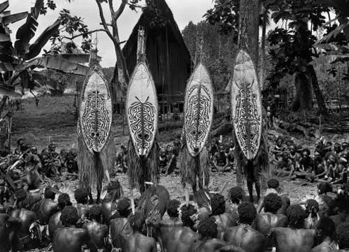 Masked dancers at Kinomere village, Urama Island, Gulf Province, PNG. January 1923. Photo by Frank Hurley courtesy of the Australian Museum